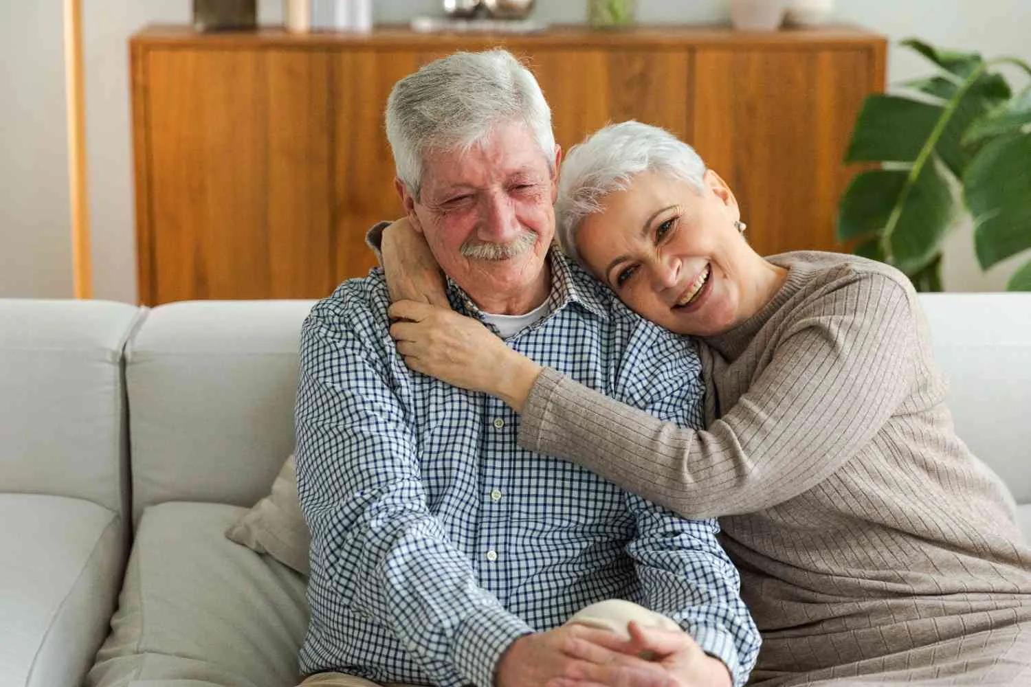 An older couple sitting together on their sofa at home